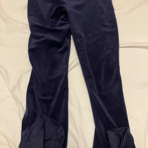 Mörkblå sammetsbyxor Gina Tricot XS - Mörkblå sammetsbyxor från Gina Tricot i storlek XS. Byxorna har en snygg bootcut-modell med vida ben och är tillverkade i mjuk sammet som ger en lyxig känsla. Perfekta för dig som vill sticka ut med en trendig look.