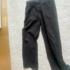 Svarta linne byxor från H&M i linne  - Svarta byxor från H&M i mjuk bomull. De har en rak passform med resår i midjan och sidfickor. Perfekta för en chill och avslappnad stil. Passar dig som gillar basic och bekvämt.