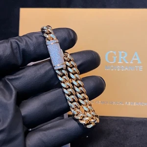 Cuban Link Guld Äkta VVS Kistlås - Exklusiv cuban link armband som är en riktig blickfångare! Utrustat med ett kistlås utsmyckt med äkta hand-set VVS moissanite stenar som passerar diamant testare. Kameran gör inte rätt för hur mycket stenarna lyser i verkligheten! 18.5cm lång och 8mm bred. Låset är tillverkat i äkta 925 silver och resten av kedjan är i 316L stål, hela kedjan har ett tjockt lager guldplätering, stämpel 10K för en autentisk känsla och look! Medföljer ask samt certifikat.