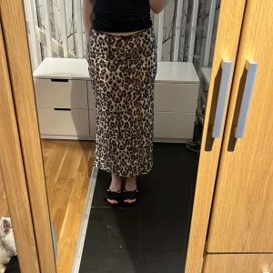 Leopardmönstrad långkjol - Säljer en snygg långkjol med leopardmönster. Kjolen har rak passform och är i ett mjukt, lätt material som faller fint. Aldrig använt 