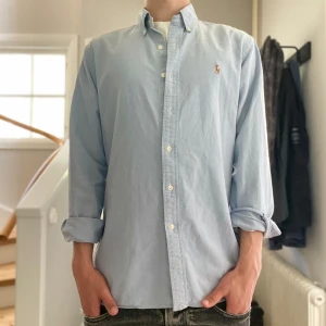 Ljusblå Ralph Lauren skjorta  - Ljusblå Ralph Lauren skjorta i mycket bra skick förutom en jätte liten lagning(se bild4) | Storlek: M | Jag är 182cm och väger 65kg📏| Vid frågor eller pris diskussion är det bara att skriva ✍🏼 | Frakt inom 48h📦