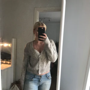 Grå stickad kofta från KappAhl - Supermysig grå stickad kofta från KappAhl med hålmönster och stora knappar framtill. Inga defekter 