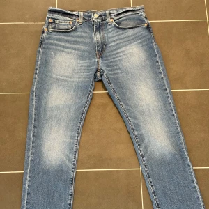 Levi's 511 blå jeans W34 L30 - Blå Levi's 511 jeans med fickor och raka ben. Jeansen har en tvättad look och är tillverkade i slitstarkt denim. Passar perfekt till vardags. Normala i storlek. Priset är inte hugget i sten 