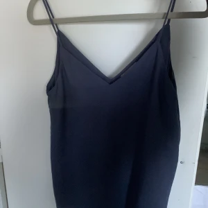 Mörkblått linne från H&M 🎀 - Snyggt grå - mörkblått linne från H&M i storlek  34 (S) ❤️ Har en liten fläck (se bild) men går säkert bort i tvätten!💛