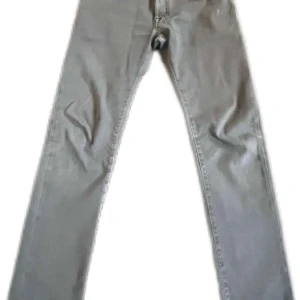 Grå jeansbyxor från Jacob Cohen W33 - Snygga grå jeansbyxor från Jacob Cohen med klassisk femficksdesign och raka ben. Byxorna har bälteshällor, knappgylf och diskret logotyp-patch bak. Perfekta för en stilren och avslappnad look.