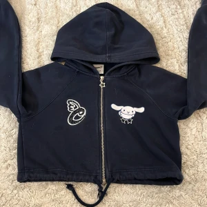 Cinnamoroll hoodie från Bershka, marinblå - Marinblå hoodie från Bershka x Cinnamoroll med dragkedja och stjärnformad zip. Söt Cinnamoroll-tryck fram och bak, samt broderad detalj. Huva och snörning nertill. Perfekt för dig som älskar kawaii och streetstyle. Använd men inga defekter!💞💖 Tvättas innan jag skickar 🤗