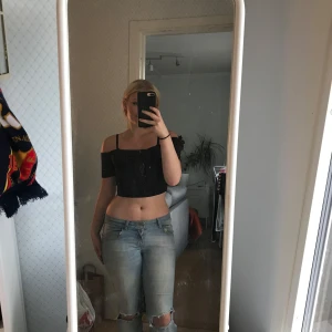 Svart croppad offshoulder topp - Säljer en svart croppad topp med offshoulder-design och smala axelband. Köpte i Spanien