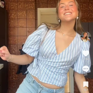 Blåvit randig omlottopp - Säljer en blåvit randig omlottopp med korta ärmar och knyt i midjan. 