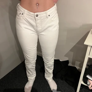 Vita raka jeans - Säljer ett par vita jeans med normal passform och raka ben. Byxorna har klassisk femficksdesign, bälteshällor och knappgylf. Perfekta för dig som vill ha en clean och stilren look.