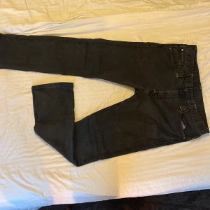 Svarta jeansbyxor Levis 514 - Säljer ett par svarta Levis 514 jeans med klassisk femficksdesign och raka ben. Jeansen har Levis-lapp bak i midjan och detaljer i kopparfärgad metall. Perfekta för dig som gillar en tidlös och enkel stil.
