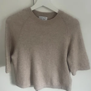 Beige stickad T-shirt från & Other Stories - Mysig beige stickad tröja från & Other Stories med rund halsringning och halvlånga ärmar. Tröjan har en avslappnad passform och är perfekt för lager-på-lager-stil. Skulle säga att den sitter som S🥰