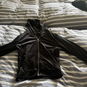 Svart hoodie med dragkedja från Lager 157 - Säljer en svart hoodie från Lager 157 i storlek M. Tröjan har dragkedja framtill, huva och två stora fickor på magen. Perfekt för en avslappnad stil och enkel att matcha med det mesta. Materialet känns mjukt och bekvämt.