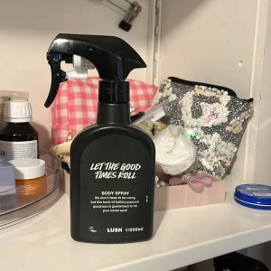 Let The Good Times Roll Body Spray från Lush heltny  - helt ny  oanvänd En svart sprayflaska med body spray från Lush, 'Let The Good Times Roll'. Flaskan rymmer 200 ml och har en praktisk sprayfunktion. Texten på framsidan är vit och designen är enkel och modern.