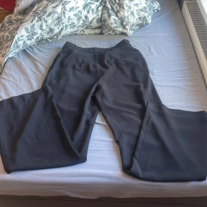 Svarta kostymbyxor från H&M - Säljer ett par svarta kostymbyxor från H&M i storlek 36. Byxorna har normal passform med raka, vida ben och klassisk midja. Perfekta till en stilren look och passar till många olika tillfällen.