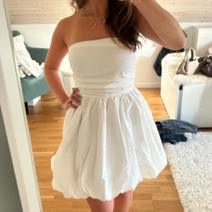 Vit klänning - Super söt vit axelbandslös klänning med ballongkjol. Endast använd en gång!