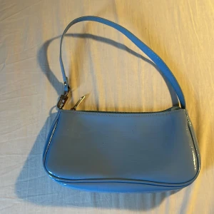 Liten blå väska! - Säljer en ljusblå axelväska! Säljer pga kommer inte till användning 💞använd cirka 2 gånger! Nypris cirka 120kr