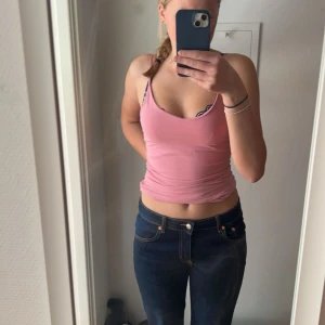 Rosa croppad linnetopp - Säljer en rosa croppad linnetopp med smala axelband. Perfekt för varma dagar och enkel att matcha med jeans eller kjol. Tunt och mjukt material som känns skönt mot huden.