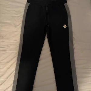 Moncler byxor  - Svarta fina sällsynta Moncler mjukisbyxor med små gråa paneler längs sidorna. Passar avslappnad och sportigt men med den extra touchen av stil som passar alla tillfällen. Som nya pris kan diskuteras vid snabb affär.