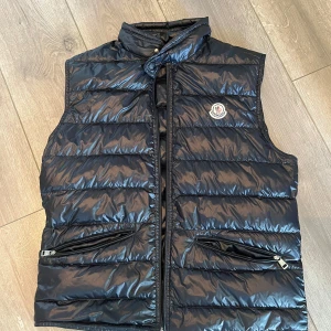 Navy gui väst från Moncler - Snygg mörkblå dunväst från Moncler i stolek 3 perfekt nu till sommaren. Skick 9/10 inga skador eller liknande hör av dig om du intresserad av fler bilder eller vad som helst 
