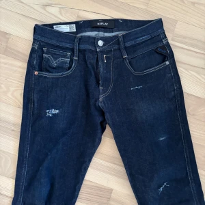 Replay Anbass jeans mörkblå - Mörkblå Replay Anbass hyperflex. Skitsnygga och diskreta slitningar med snygga kontrastsömmar. Midjemått W28 och längd L32. Dom är vi väldigt fint skick men enda felet är att läderlappen bak i byxlinningen är lite trasig (inget som märks vid användning). Nypris ca 1500kr. Hör av er vid minsta fråga och pruta gärna. 