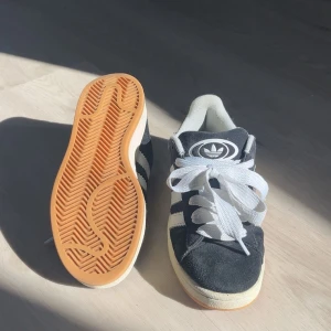 Adidas Campus 00s - Ett par adidas campus i toppskick, dem är använda fåtal gånger. Finns inga större tecken på defekter, än att inne sulan är väldigt lite sliten längst upp. ( Skriv för fler bilder). Ny pris: 1499 säljer för 900 köpta på Nellys hemsida. Storleken är 37 1/3.