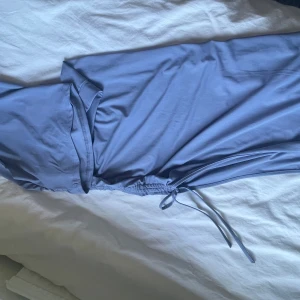 Ljusblå sett med knyt i midjan - Säljer en ljusblå sett med knyt i midjan. Settet har en enkel och stilren design med mjukt fallande tyg. Perfekt för dig som gillar minimalistisk stil och vill ha något bekvämt men ändå snyggt.