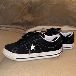 Svarta skor - Converse One Star PRO - Säljer mina Converse One Star Pro då de inte kommer till användning längre. Strl 38. Äkta mocka läder. Inköpspris 800kr. I fint bevarat skick. Sparsamt använda.