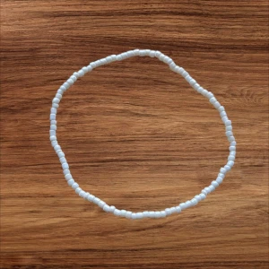 Vitt pärlarmband  - Enkel och stilrent armband med små vita pärlor. Perfekt för att addera en subtil detalj till din outfit. Passar lika bra till vardag som till festliga tillfällen.