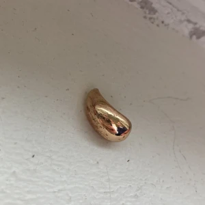 Chunky guldpläterad ring - Säljer en chunky ring i guldpläterad metall med en mjukt böjd, organisk form. Ringen har en blank yta och är riktigt statement. Perfekt för dig som gillar unika accessoarer.