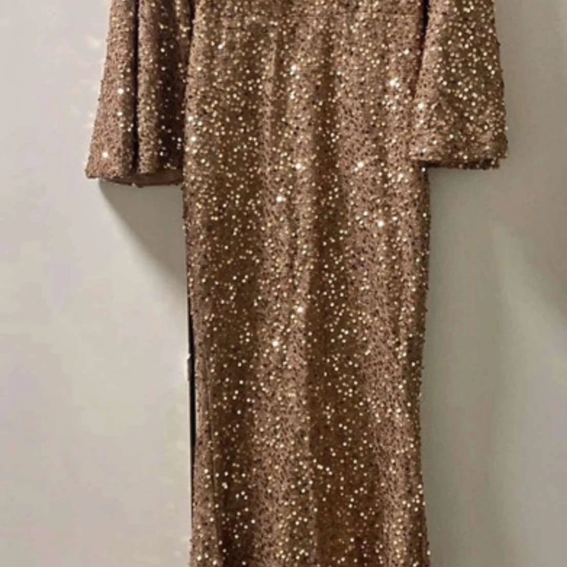 Glittrig guldklänning med trekvartsärm - 1