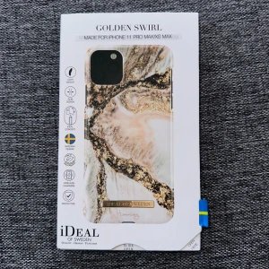 Golden Swirl mobilskal för iPhone 11 Pro Max/XS Max - Snyggt mobilskal från iDeal of Sweden i mönstret Golden Swirl. Skalets design har marmorerade inslag i vitt, beige och guld med en glansig finish. Passar iPhone 11 Pro Max och XS Max. Märkeslogga i guld på framsidan. Helt ny och oanvänd pga att jag köpte fel modell! 
