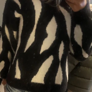Svart och vit stickad tröja - Mysig stickad tröja i svart och vitt med zebrainspirerat mönster. Säljer då jag vill köpa annat. Storlek M men passar mig som vanligtvis brukar ha S💗pris kan diskuteras.