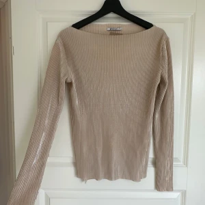 Beige ribbad långärmad topp från Gina Tricot - Säljer en beige ribbad långärmad topp från Gina Tricot. Tröjan har en smal passform och är tillverkad i ett stretchigt material som sitter snyggt på kroppen. Perfekt att styla till jeans eller kjol.