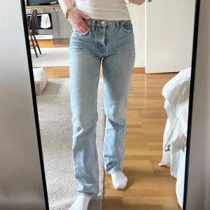 Ljusblå raka jeans - Säljer ett par klassiska ljusblå jeans med rak passform och normal midja. Jeansen stängs med  knappar. Perfekta till vardags för en avslappnad stil.
