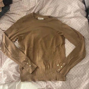 stickad tröja med knappar - Säljer en beige stickad tröja från holly & whyte med guldiga knappar. 