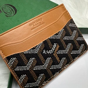 Brun och svart korthållare  - Säljer en snygg korthållare i brunt och svart. Korthållaren har flera fack för kort. Perfekt accessoar för dig som vill ha stilren förvaring.