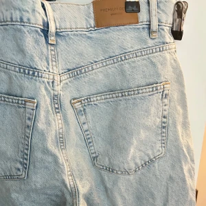 Ljusblå jeansshorts - Ljusblå jeansshorts från Gina Tricot. Klassisk femficksmodell med dragkedja och knapp framtill. Shortsens längd går till strax ovanför knäna. 