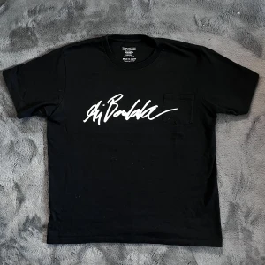 Eytys t-shirt - Säljer en svart t-shirt från Eytys med vit grafisk text på bröstet och en liten bröstficka. T-shirten är tillverkad i 100% bomull och har en klassisk passform med korta ärmar. Perfekt för en stilren och modern look. Storlek XL men sitter som L, Skick 10/10, pris går att diskutera✅