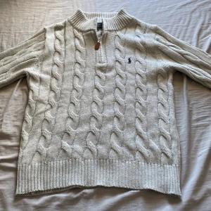 Grå stickad tröja från Polo Ralph Lauren - Säljer en grå stickad tröja från Polo Ralph Lauren med halv dragkedja. Tröjan har klassisk logga broderad på bröstet. Perfekt för kyliga dagar och snyggt till jeans. Helt nytt skick och bara testad fåtal gånger. Storleken är small och ordinarie pris på tröjan är 1499. Hör av er ifall ni har frågor🙂