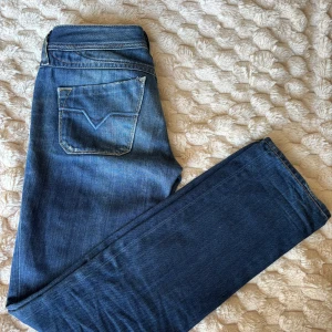 Blå lågmidjade jeans från Diesel - Jeans från diesel med lite unika sömmar, speciellt bak! Innerbenslängd: 76cm. Midjemått (rakt över): 36. Grenhöjd: 17.5cm. Skriv om du har övriga frågor!