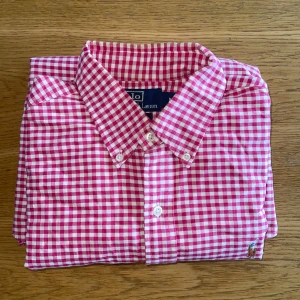 Rutig skjorta från Polo Ralph Lauren - Säljer en klassisk röd- och vitrutig skjorta från Polo Ralph Lauren.  Det fins en missfärgning på kragen som ni kan se på tredje bilden