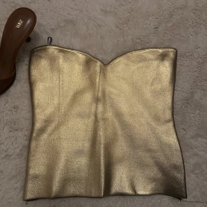 Guldig fest topp  - Super snygg topp i guld. I nyskick aldrig använd. 