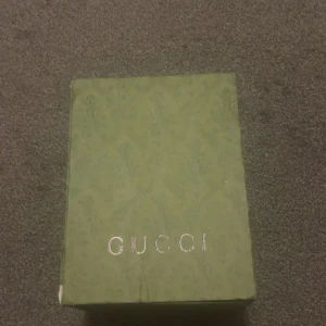 Gucci keps med tiger och GG-mönster - Säljer en snygg Gucci keps med klassiskt GG-mönster i beige och brunt. Framsidan har en broderad tiger i gult, svart och vitt. Baksidan är i svart mesh för extra ventilation. Kepsen kommer med originalbox och dustbag.