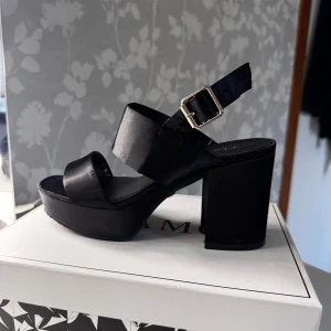 Svarta sandaler med platå och klack - Snygga & stabila klackar – storlek 36 🖤 Bekväma svarta klackar med bred klack och stadig passform – perfekta för dig som vill ha stil och komfort! Klacken är inte särskilt hög, vilket gör dem enkla att gå i, även längre stunder.  ✔️ Stabil modell ✔️ Stilren och passar till allt ✔️ Endast använd ett fåtal gånger  ✔️ Perfekt för fest, middagar eller vardagslyx!  Pris innan: 599kr Pris nu: 230kr