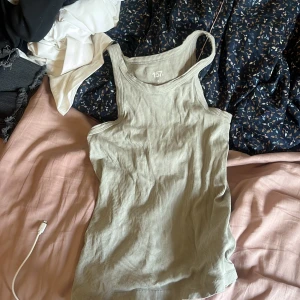 Ljusgrön ribbad linnetopp 157 - Säljer en ljusgrön ribbad linnetopp från 157. Toppen är ärmlös med klassisk rund halsringning och tillverkad i mjuk bomull. Perfekt att styla med jeans eller shorts för en enkel och clean look.