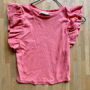 Rosa ribbad topp med volangärmar - Söt och fin rosa topp från Zara. Supertrendig och slutsåld passar till det nästa och skön att bära.Säljer pågrund av att den har blivit för liten.
