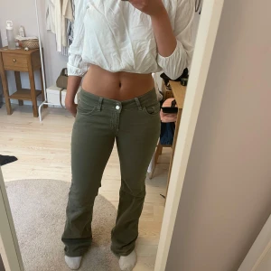 slutsålda Helt nya lågmidajde Nelly jeans som är gröna! - Snygga olivgröna byxor med bootcut-snitt och vita broderade detaljer på bakfickorna. Klassisk femficksmodell med låg midja och bekvämt bomullsmaterial. Perfekta för dig som vill ha en cool och avslappnad stil.