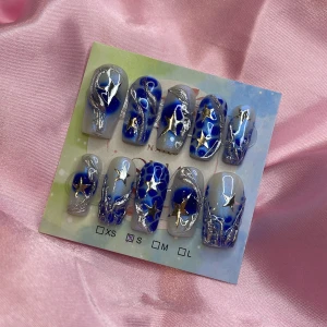 St4rBby08 (S);Medium Square - Snygga gelé press-on naglar i storlek S: 15 mm, 11,5 mm, 12 mm, 11 mm, 9 mm , med blå och silver design, dekorerade med silver3D nailart- och silverstjärnor samt glitterdetaljer. Naglarna har en cool mönstrad look. Perfekt för dig som vill sticka ut med en unik och trendig nagelstil.