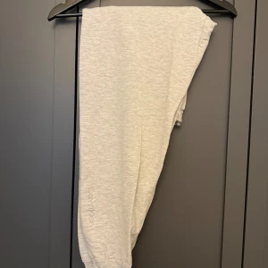 Ljusgrå mjukisbyxor Calvin Klein S - Ljusgrå mjukisbyxor från Calvin Klein med elastisk midja och logga på mudden. 