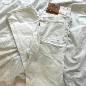 Vita Levi's 501 jeans straight fit - Säljer ett par klassiska vita Levi's 501 jeans med raka ben och knappgylf. Vintage! Jätte fint skick. Några få tecken på användning inklusive mappen där bak, se bild. Men inget man tänker på.